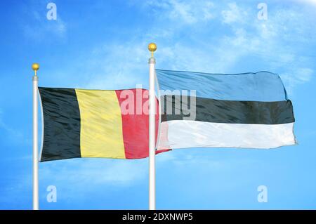 Belgique et Estonie deux drapeaux sur les mâts de drapeaux et bleu nuageux ciel Banque D'Images