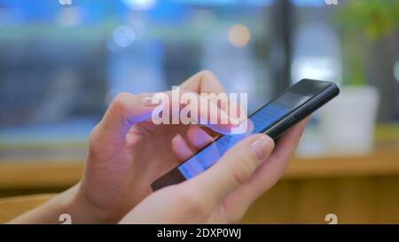 Woman using smartphone in cafe Banque D'Images