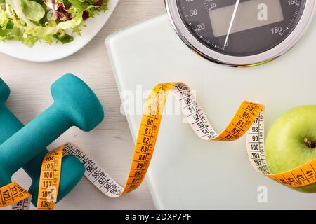 Contexte conceptuel de vie saine avec des balances de haltères et une alimentation saine. Vue de dessus. Composition horizontale. Banque D'Images