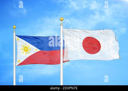 Philippines et Japon deux drapeaux sur les mâts et bleu nuageux ciel Banque D'Images