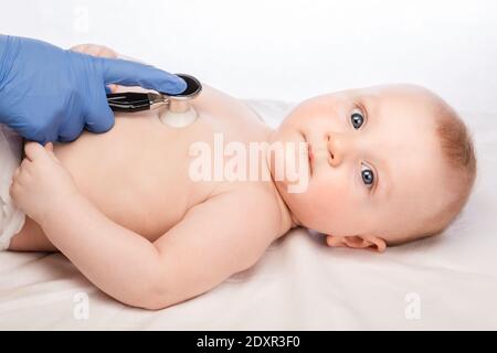 Le pédiatre examine la poitrine de bébé garçon de 5 mois en clinique pédiatrique. Médecin utilisant un stéthoscope pour vérifier le rythme cardiaque et les poumons Banque D'Images