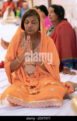 Un adorateur hindou dévot prie et médite iat un service du dimanche matin à l'intérieur d'un temple à South Richmond Hill, Queens, New York City. Banque D'Images