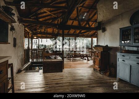 Grande terrasse ouverte avec mobilier artisanal artisanal en bois de chêne. Ancienne cour avec poutres en bois sur le toit dans la maison traditionnelle de village de campagne Banque D'Images