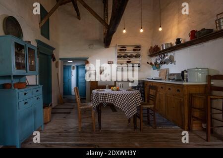 Intérieur traditionnel de la cuisine du vieux village dans une maison de campagne historique avec des murs en stuc, des poutres en bois, des meubles en chêne, des ustensiles de cuisine vintage Banque D'Images