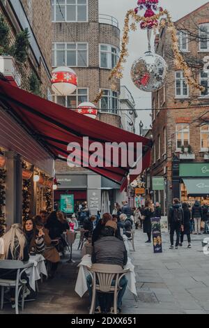 Londres, Royaume-Uni - 5 décembre 2020 : les gens aux tables extérieures d'un restaurant de St Christopher's place, un quartier urbain animé de Londres avec des hig Banque D'Images