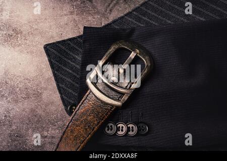 Illustration d'une ceinture en cuir avec boucle de ceinture chromée sur les parties d'un gilet rayé gris et partie d'une manche d'une veste Banque D'Images