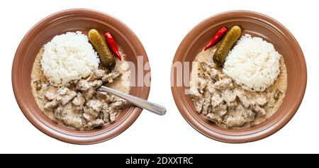 Ensemble de bœuf Stroganoff (bœuf Stroganov, Befstroganov) plat russe de viande compotée dans la crème aigre avec du riz bouilli sur la plaque brune isolée sur le dos blanc Banque D'Images