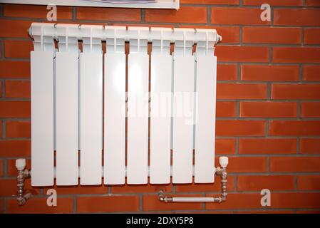 radiateur de chauffage domestique blanc sur mur de briques Banque D'Images