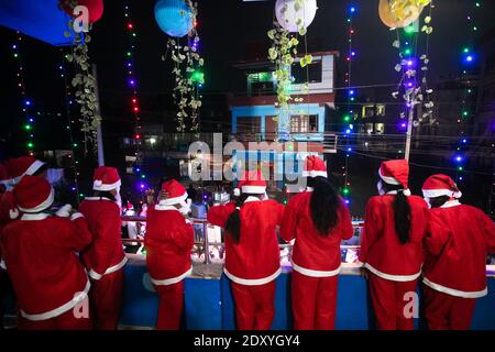 Les garçons et les filles népalais habillés comme le Père Noël prennent part aux chants de Noël lorsqu'ils célèbrent la veille de Noël à l'église HCM. La veille de Noël est la soirée ou toute la journée avant le jour de Noël, le festival commémorant la naissance de Jésus-Christ. Le jour de Noël est observé dans le monde entier. Banque D'Images