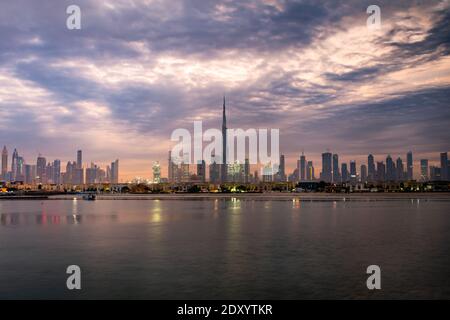 Lever du soleil à Dubaï avec vue ciel nuageux depuis le bateau ou la mer. Le soleil se lève au-dessus des gratte-ciels des Émirats arabes Unis le matin. Plage de Dubaï, côte, côte Banque D'Images