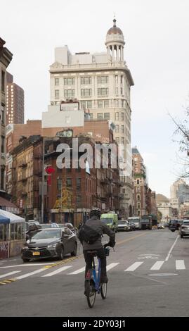 En regardant vers l'ouest sur Canal Street depuis Essex sur le Lower East Side, New York City avec le bâtiment classique de la banque Jarmulovsky qui s'élève dans le ciel. La banque de Jarmulovsky, située à l’angle sud-ouest des rues Canal et Orchard, a été construite en 1912 comme une banque privée par l’ancien marchand de rue, l’expéditeur Jarmulovsky, qui a créé une banque avec son épargne en 1873, servant ses compatriotes du Bas-Orient de moyens modestes. Pendant ses premières années, la banque de Jarmulovsky a connu un véritable succès dans un quartier d’épargnants et il a engagé la firme d’architectes Rouse et Goldstone pour construire une magnifique banque Banque D'Images