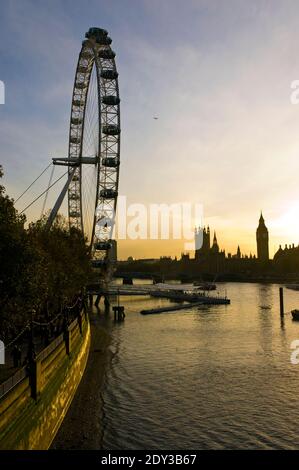 Le Parlement et le coucher du soleil de Big Beat, vus derrière le London Eye, une grande roue sur la rive sud de la Tamise, Londres, Angleterre. Banque D'Images