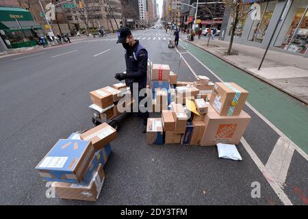 New York, États-Unis. 24 décembre 2020. S'étendant sur second Avenue derrière son camion, un employé DE FEDEX trie les colis qui seront livrés le 24 décembre 2020 à la veille de Noël, à New York, dans l'État de New York. Avec la résurgence des infections COVID-19, les services d'expédition de colis tels que FEDEX, UPS et USPS prévoient de livrer un nombre record de paquets pour 2020. (Photo par Anthony Behar/Sipa USA) crédit: SIPA USA/Alay Live News Banque D'Images