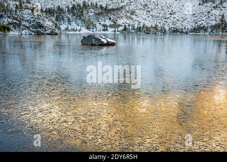 WA18823-00...WASHINGTON - la lumière du soleil se reflète sur l'eau couverte de glace du lac Ethel dans la région sauvage des lacs alpins. Banque D'Images