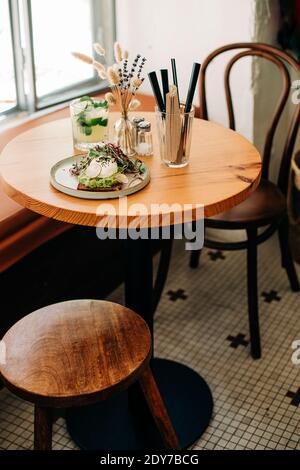 Toast à l'avocat sur l'assiette, table dans le café servi pour le petit-déjeuner ou le brunch Banque D'Images