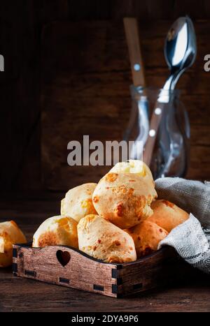 Petits pains au fromage doré sur plateau en bois, table de cuisine rustique, espace de photocopie Banque D'Images