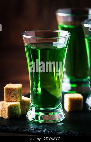 Absinthe - boisson alcoolisée forte, teinture de bois de millepertuis vert amer en verres sur l'ancienne table en bois, place pour le texte Banque D'Images