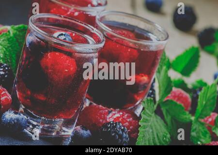 Boisson aux baies fraîches avec bleuets, mûres et framboises, mise au point sélective et image tonifiée Banque D'Images