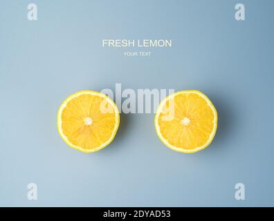 Deux moitiés d'un citron juteux mûr sur fond gris. Banque D'Images