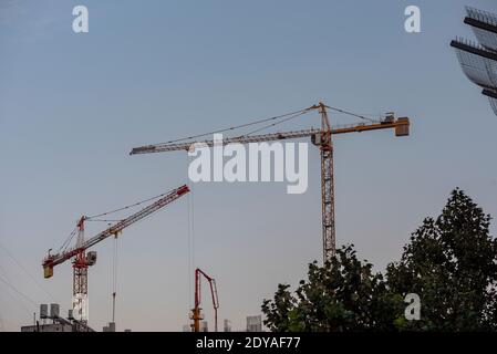 Paysage industriel avec des silhouettes de grues sur le fond coucher de soleil Banque D'Images