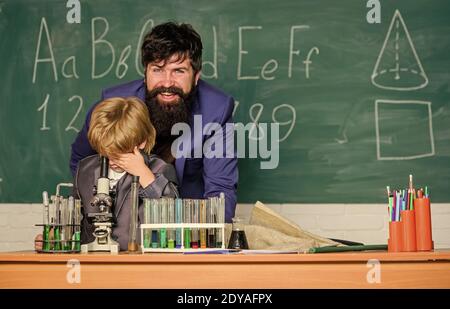 La biodiversité que nous devrions conserver. Chimie et biologie physique. Fils et père à l'école. Flacon à la main du scientifique avec tubes à essai. Sagesse. Retour à l'école. Petit garçon avec professeur. Banque D'Images