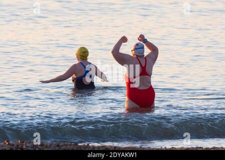 Mudeford, Dorset, Royaume-Uni. 25 décembre 2020. Météo Royaume-Uni. Les nageurs vont se baigner dans la mer à Avon Beach à Mudeford à Dorset, le jour de Noël, lors d'une matinée froide et ensoleillée. Crédit photo : Graham Hunt/Alamy Live News Banque D'Images