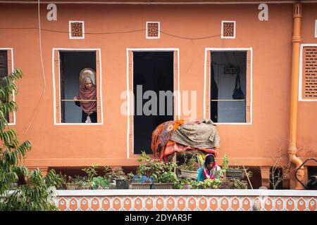 Une femme âgée regarde par la fenêtre pendant le confinement de Covid-19 en Inde. Banque D'Images