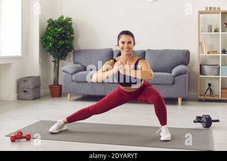 Bonne jolie jeune femme athlète de sport faisant de l'entraînement avec squats pour les jambes Banque D'Images