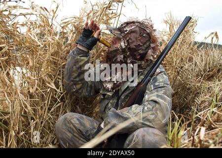 le chasseur de canards s'est caché à l'aveugle des roseaux et leurres les canards Banque D'Images