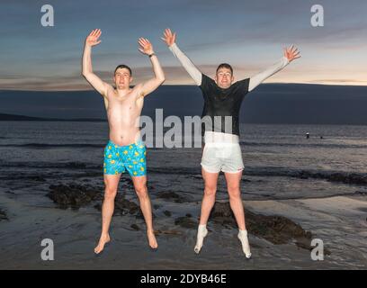 Myrtleville, Cork, Irlande. 25 décembre 2020.Shane Murphy et Thomas O'Driscoll sautent pour la joie après leur petit matin jour de Noël nagez à Myrtleville, Co. Cork, Irlande. - crédit; David Creedon / Alamy Live News Banque D'Images