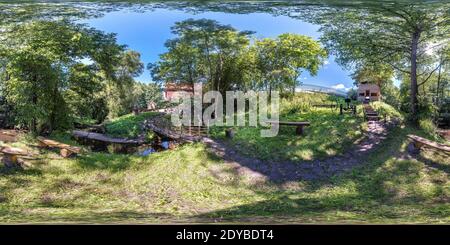 Vue panoramique à 360° de vue en angle de 360 degrés du panorama hdri sphérique sans couture buissons et arbres de lieu de repos par le vieux moulin et rivière étroite en p équirectangulaire