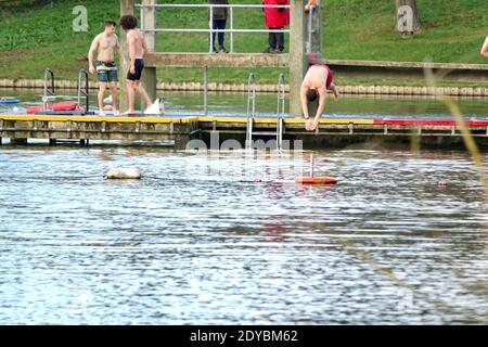 L’homme plonge dans un étang à Hampstead Men’s Pond pour un événement annuel de natation de Noël le jour de Noël 2020. Banque D'Images