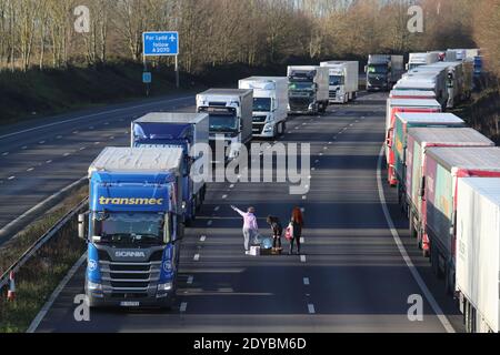 Trois femmes mettent de la nourriture et de l'eau à la disposition des conducteurs sur la M20 près d'Ashford, dans le Kent, où des centaines de voyageurs passent le jour de Noël en attendant de reprendre leur voyage vers le port de Douvres et de l'autre côté de la Manche maintenant que les frontières avec la France ont rouvert. Banque D'Images