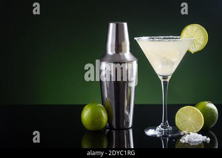 Cocktail mexicain typique de margarita avec glace à la lime et shaker à cocktail sur fond noir et vert. Avec espace de copie Banque D'Images