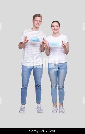 Couple met sur le masque médical debout isolé. Protection de la santé, soins médicaux, couple, famille, concept de virus Banque D'Images