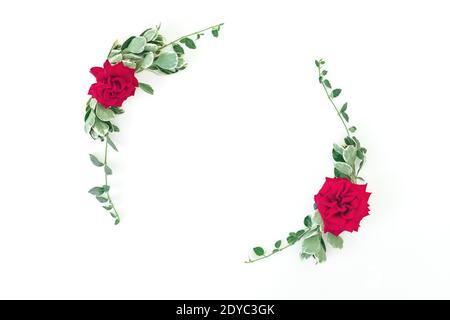 Cadre rond en roses rouges et feuilles sur fond blanc. Flat Lay, vue de dessus Banque D'Images