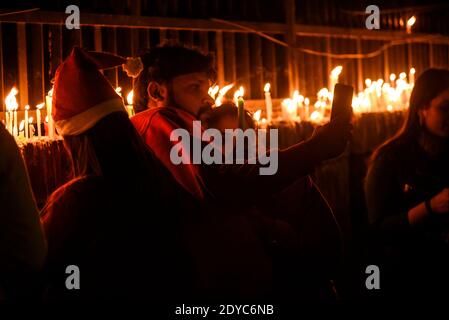 New Delhi, Inde. 25 décembre 2020. Les gens prennent le selfie à l'extérieur de la cathédrale du Sacré-cœur à l'occasion des célébrations de Noël, au milieu de la propagation de la maladie du coronavirus (COVID-19), à New Delhi le 25 décembre 2020. La plus grande église de Delhi, la cathédrale du Sacré-cœur, s'est arrêtée à Noël pour la toute première fois à la suite du coronavirus. Crédit : David Talukdar/ZUMA Wire/Alay Live News Banque D'Images