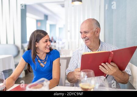 Homme mature et jeune femme appréciant et souriant, passant du temps ensemble Banque D'Images