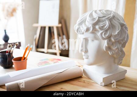 Intérieur du studio de peinture de l'artiste indépendant. Tête de gypse, brosses, corps de coq, encre sur la table Banque D'Images