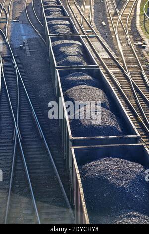 le charbon noir dans les wagons sur les rails est déplacé au point de déchargement suivant dans la logistique Banque D'Images