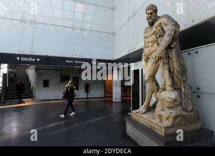 Les gens marchent dans l'incroyable station de métro Museo à Naples, en Italie, le 1er février 2013. Dans cette station, les navetteurs sont accueillis par un Hercules gigantesque. Dans la ville italienne tumultueuse et chaotique, le métro le plus extraordinaire du monde est né. Imaginés par les plus grands architectes d'Italie, les gares ressemblent à un musée fantastique. L'idée est simple : rapprocher l'art contemporain des navetteurs, qui sont par définition distraits et pressés. Les plates-formes et les couloirs du métro de Naule sont parsemés de peintures, sculptures, fresques, mosaïques et photographies. Pas besoin de se fermer dans un museu Banque D'Images