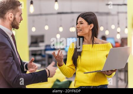 Le responsable explique à son employé comment terminer ses tâches. Collègues discutant d'un projet en se tenant dans un bureau. Banque D'Images