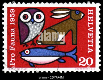 MOSCOU, RUSSIE - 22 FÉVRIER 2019 : un timbre imprimé en Suisse montre hibou, lièvre et poisson, série de bien-être animal, vers 1959 Banque D'Images