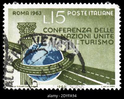 MOSCOU, RUSSIE - 22 FÉVRIER 2019 : un timbre imprimé en Italie montre la colonne, le globe et l'autoroute, série de la Conférence des Nations Unies sur le tourisme, vers 1963 Banque D'Images