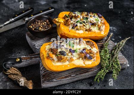 Citrouille farcie de viande de bœuf hachée, de légumes et d'herbes fond noir. Vue de dessus Banque D'Images