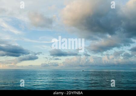Nuit tombée sur la mer des Caraïbes. Vue sur l'océan avec vagues et nuages blancs. Paysage marin reposant, mer sans fin, fond d'eaux tropicales. Mer bleue et c Banque D'Images