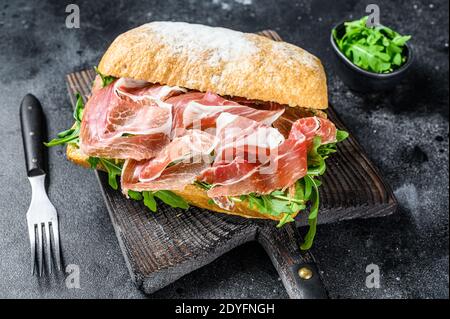 sandwich au jambon iberico sur du pain ciabatta. Arrière-plan noir. Vue de dessus Banque D'Images