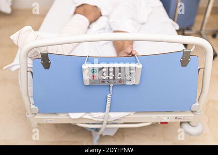 Patient allongé dans le lit d'hôpital avec une jambe cassée. Vue de dessus. Concept d'hospitalisation et de soins médicaux. Banque D'Images