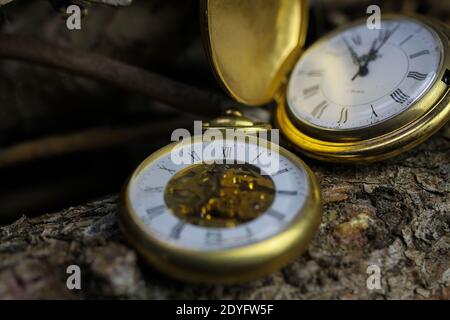 Viersen, Allemagne - Mai 9 .2020: Macro gros plan de deux montres de poche anciennes isolées dorées avec mouvement en filigrane horloge, couvercle, chaîne sur naturel b Banque D'Images