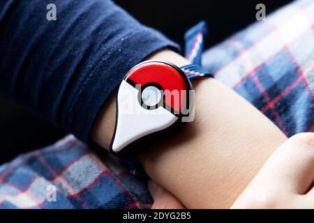 Childs main avec le nouveau jeu japonais Pokemon Go plus fabriqué par la société Pokemon Nintendo. Activité populaire addictive chez les enfants et les adultes. Banque D'Images